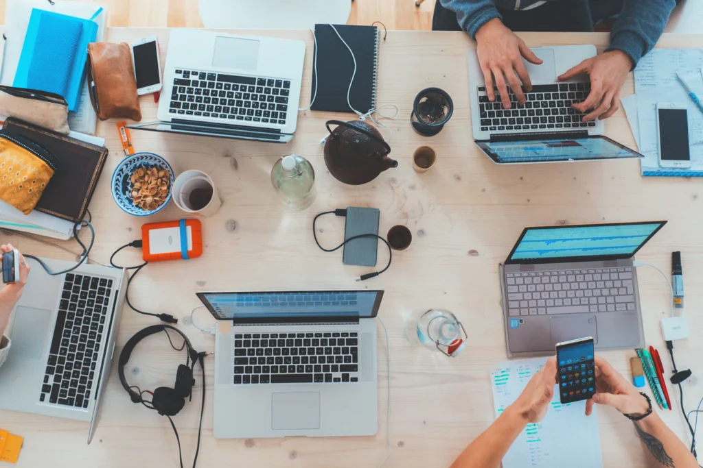 Team working around a table of laptops, seen from above
