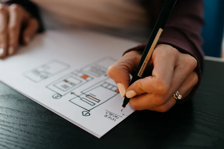 Designer sketching UI wireframes on paper